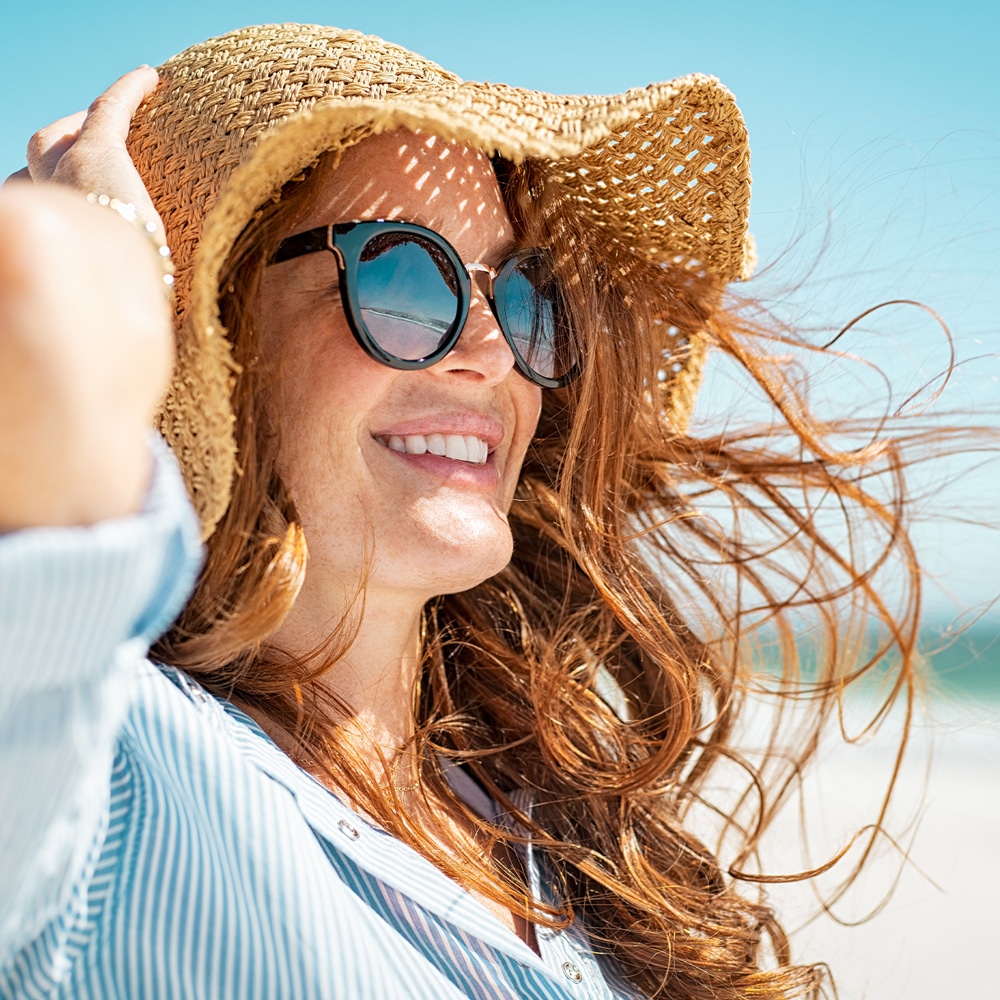 a woman wearing a hat and sunglasses