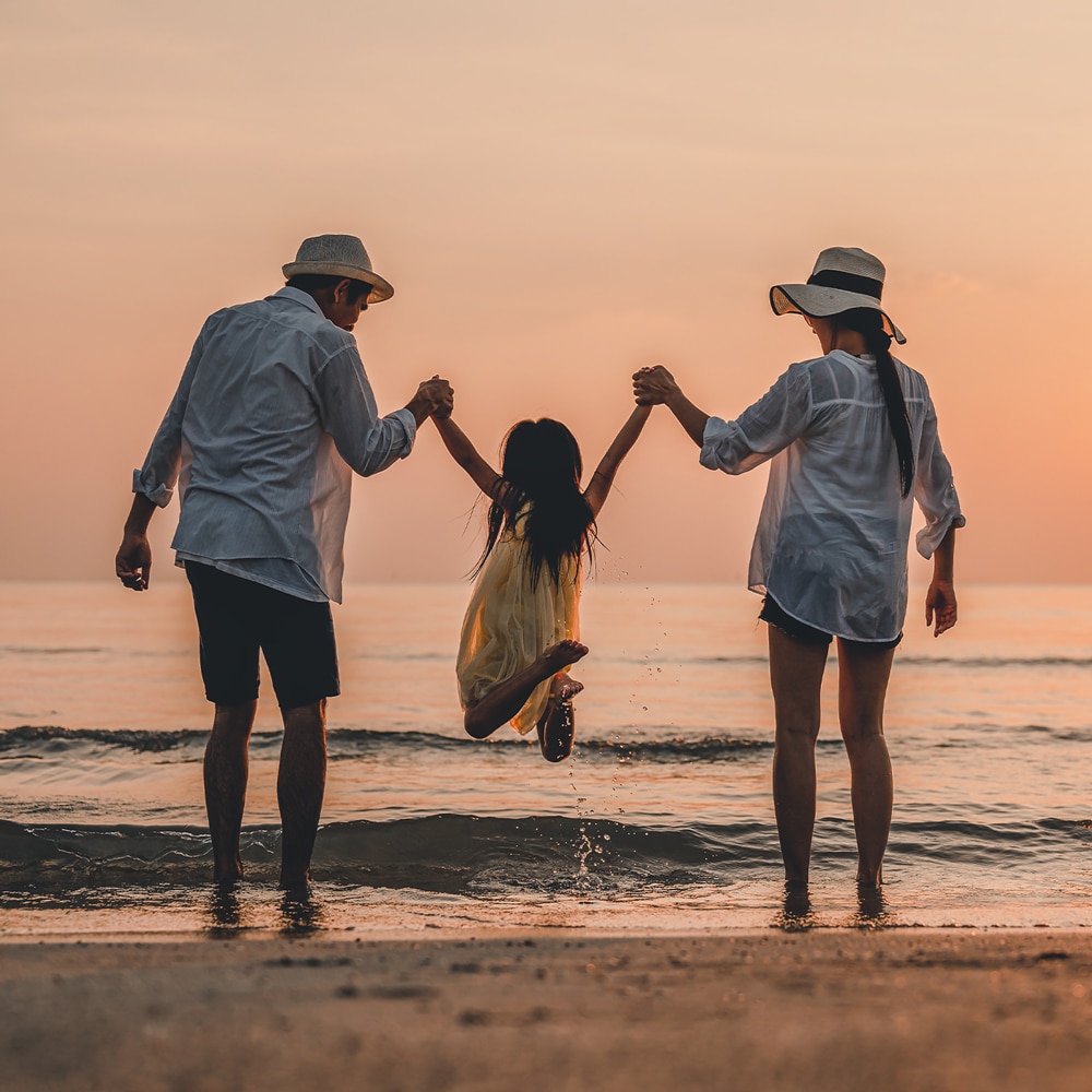 a couple of people that are standing in the sand on a beach
